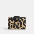 Coach medium corner zip wallet with leopard print in gold, featuring a compact design and gold zipper details.