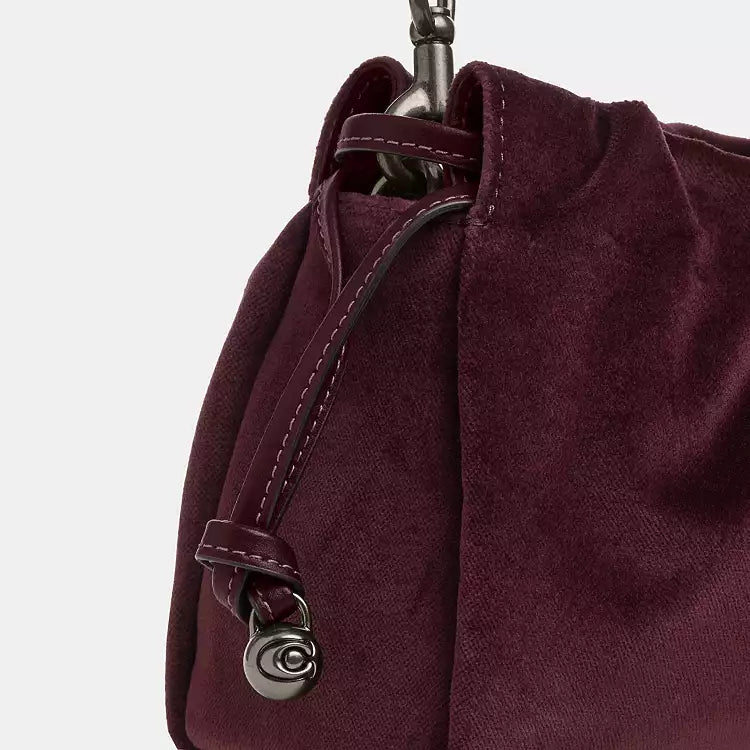 Coach Faye shoulder crossbody bag in plush velvet burgundy, stylish and compact with gold-tone hardware and adjustable strap.