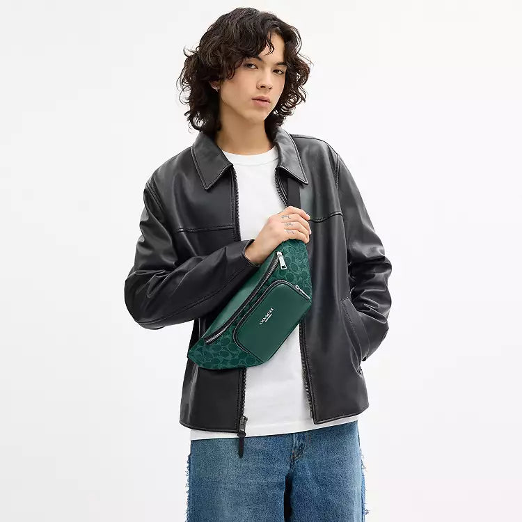 The Tiny Bag Coach Racer small belt bag in signature canvas with silver and sea green colors, featuring a compact crossbody design.