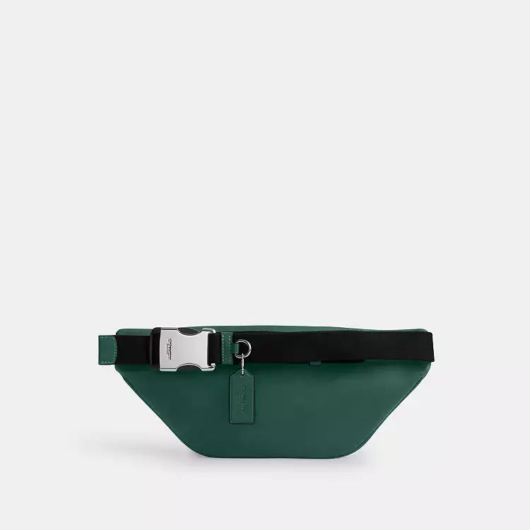 The Tiny Bag Coach Racer small belt bag in signature canvas with silver and sea green colors, featuring a crossbody strap.