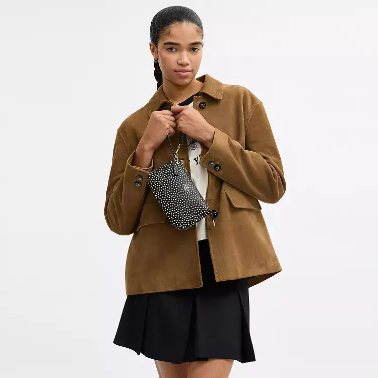 Black Coach Nolita 19 shoulder bag with spot print in refined pebble leather, featuring a compact, stylish design.