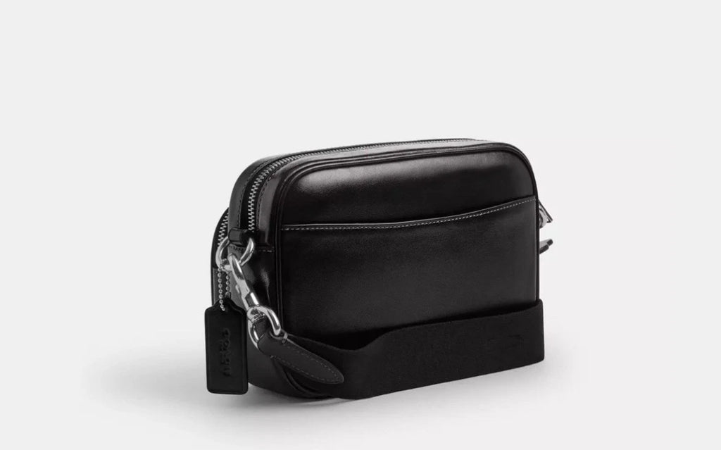 Silver and black Coach Finlay crossbody bag charm with shiny smooth leather, featuring a stylish and compact accessory.