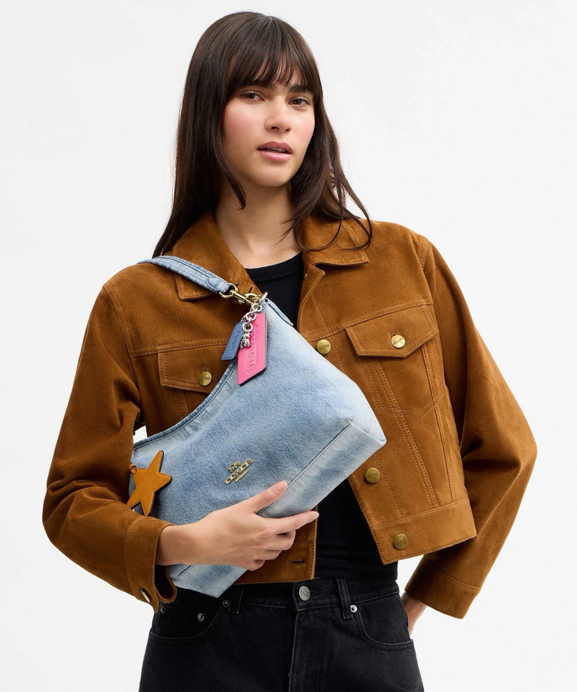 Coach CEF26 Laurel shoulder bag in light indigo denim with charms, featuring a stylish design and shoulder strap.