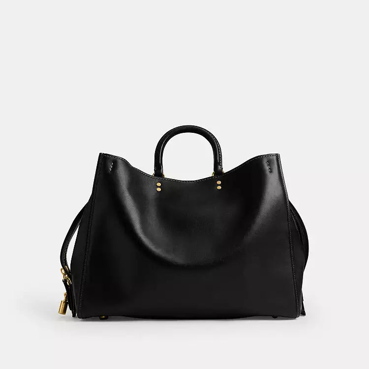 Black leather Coach Rogue Bag 40 crossbody bag with signature CC logo from The Tiny Bag, showing front view and adjustable strap.
