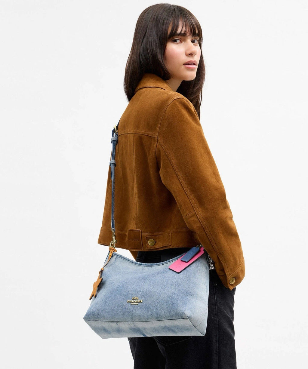 Coach Laurel shoulder bag in loved denim with charms, light indigo color, stylish and compact design by The Tiny Bag.
