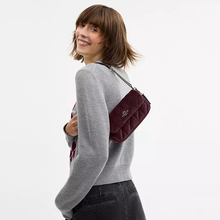 Coach Hailey Flap Bag in burgundy velvet with quilting, organic cotton shoulder bag featuring a flap closure and subtle branding.