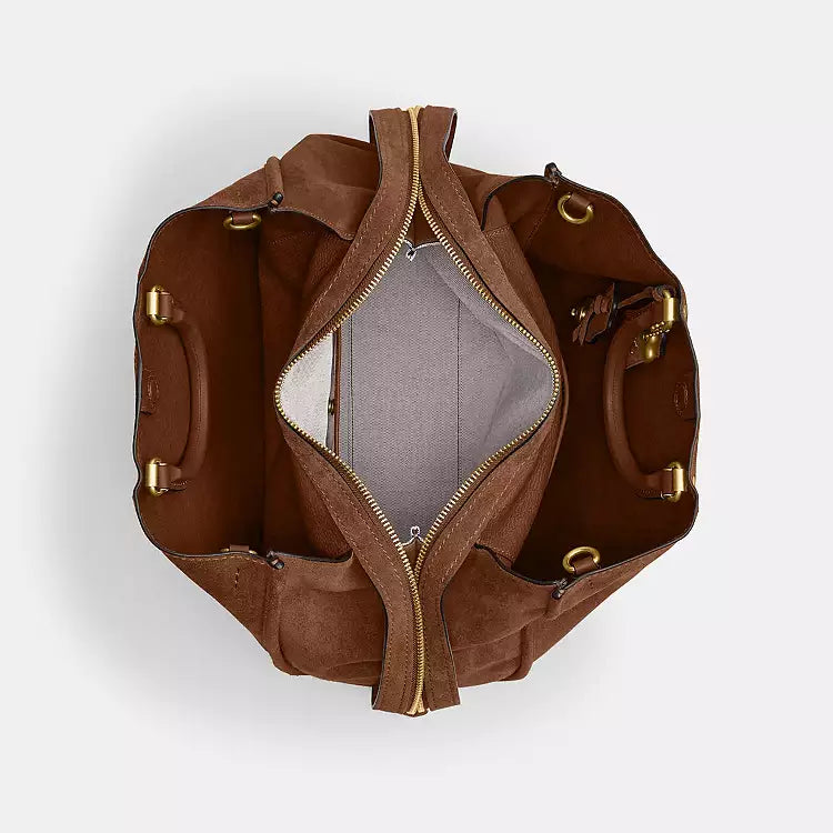 Coach Rogue 40 suede leather shoulder bag in brown with CCX66 logo, featuring a sleek, stylish design and shoulder strap.