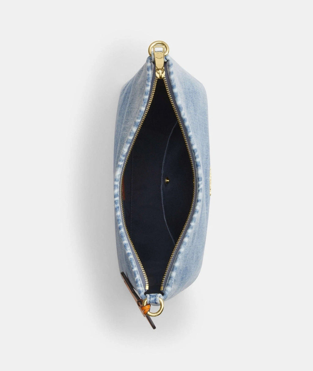 The Tiny Bag Coach CEF26 Laurel shoulder bag in light indigo denim with charms, featuring a compact design and shoulder strap.