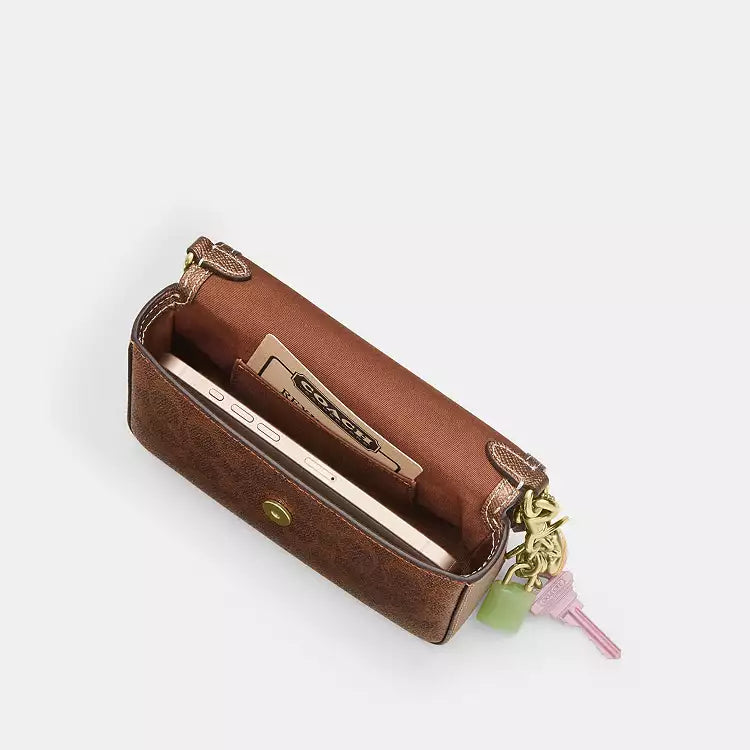 The Tiny Bag Coach Mini Josie top handle crossbody bag in signature canvas with brown and copper accents.