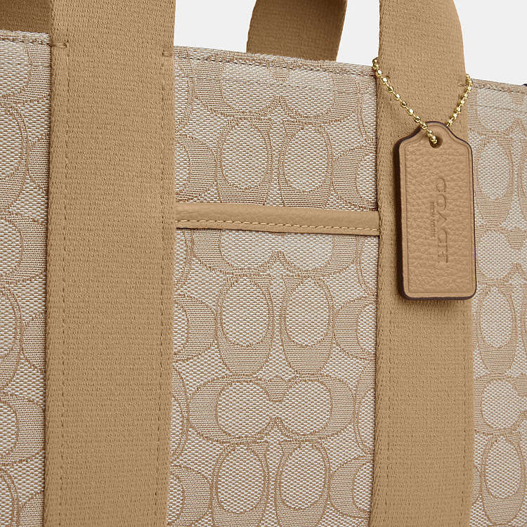 Light khaki Coach Signature Jacquard Smith Tote Bag with leather handles and logo pattern, stylish and spacious for everyday use.