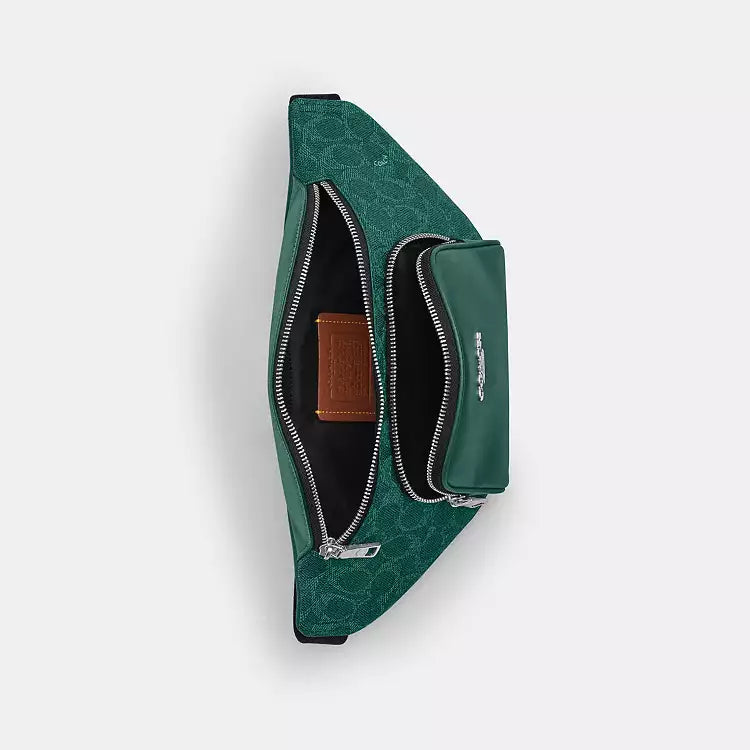 The Tiny Bag COACH Racer small crossbody belt bag in signature canvas with silver and sea green accents.