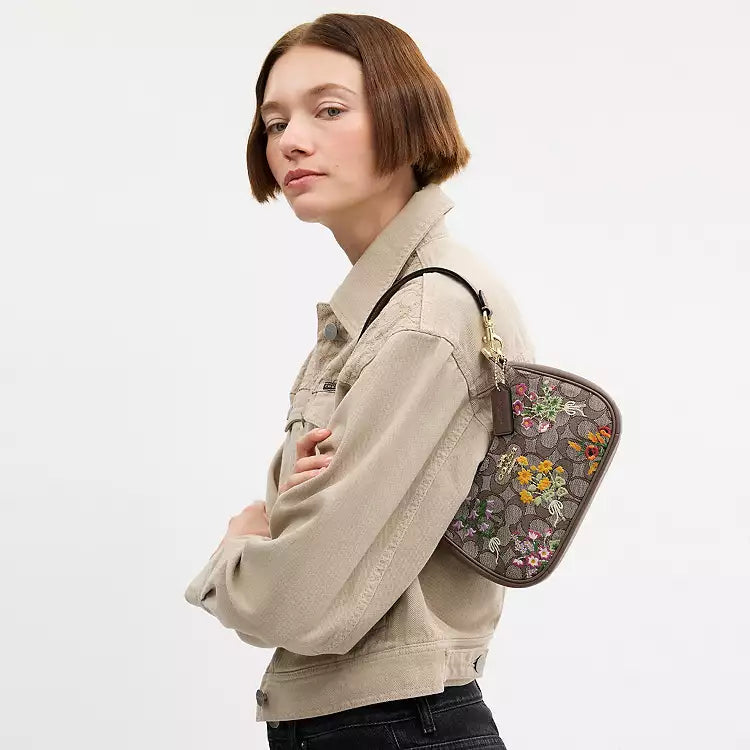 Coach Teri mini crossbody bag with signature jacquard floral embroidery, featuring a shoulder strap and compact design.