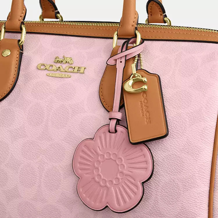 Coach Rowan large signature canvas shoulder bag with charms in powder pink, featuring a spacious design and stylish accents.