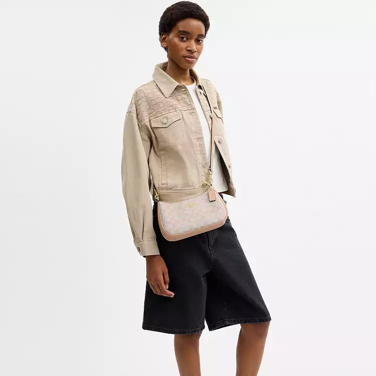 Coach Teri shoulder bag in signature canvas with gold, chalk, and pink accents, featuring a stylish, compact design.