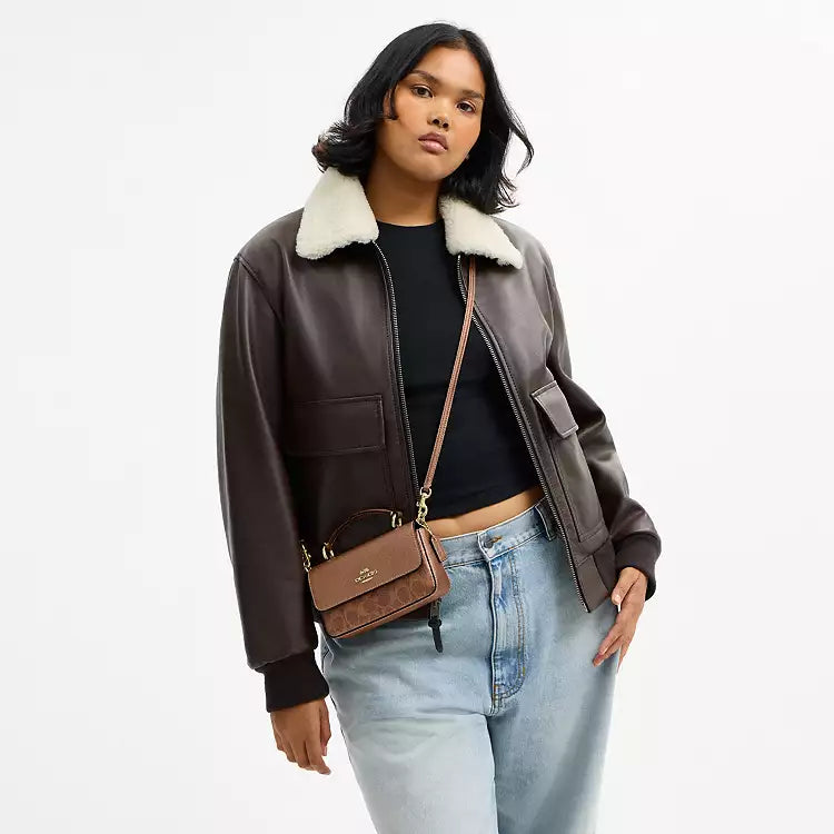 Coach Mini Josie top handle crossbody bag in signature canvas with brown and copper accents, featuring a compact design and classic style.