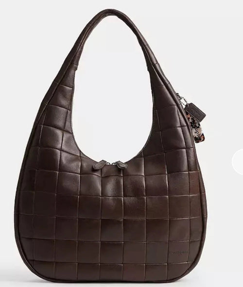 The Tiny Bag Coach Coachtopia Alter/Ego Large Crescent Shoulder Bag in maple color with visible stitching and shoulder strap.