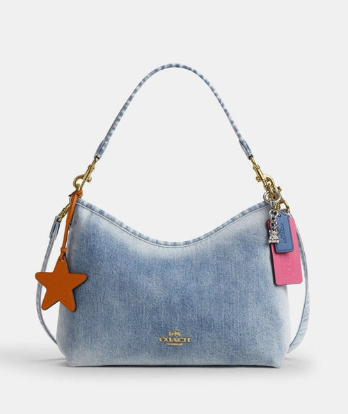Coach CEF26 Laurel shoulder bag in light indigo denim with charms, featuring a stylish design by The Tiny Bag.