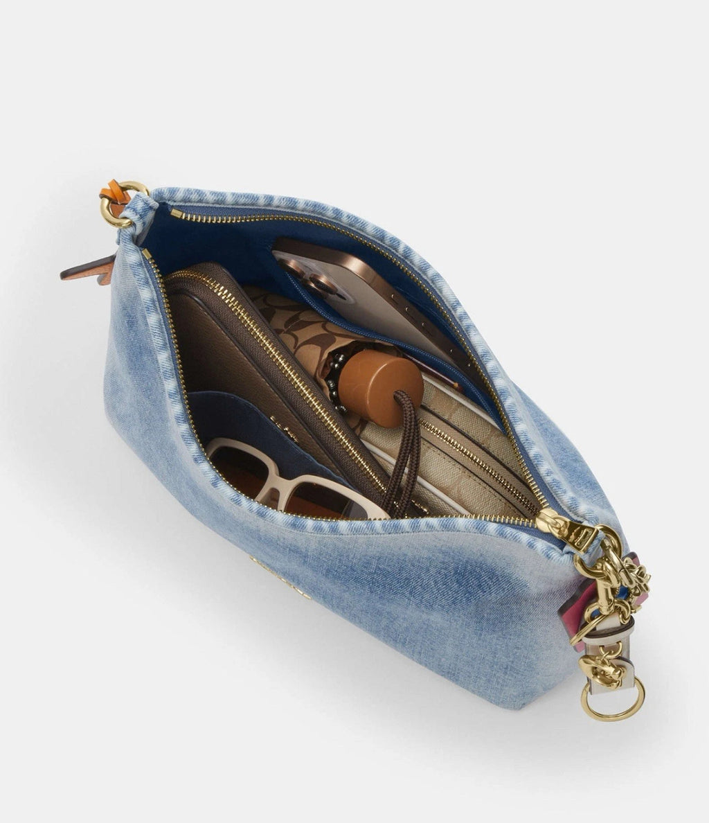 Light indigo Coach CEF26 Laurel shoulder bag in loved denim with charms, featuring a stylish and spacious design.
