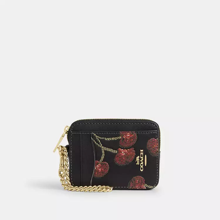 Coach CDF99 zip card case wallet with cherry print in gold and black, featuring multiple card slots and a compact design.