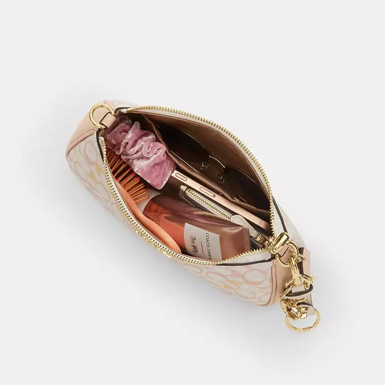 Coach Teri shoulder bag in signature canvas with gold, chalk, and pink accents, featuring a structured design and leather strap.
