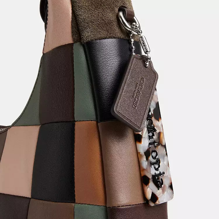 Coach Coachtopia Alter/Ego Crescent shoulder bag in leather and suede with CCX57 branding, featuring a stylish multi-colored design.