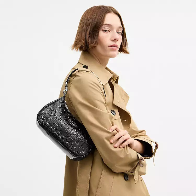 Coach Teri shoulder bag in signature leather with heart charm, stylish and compact design for everyday use.