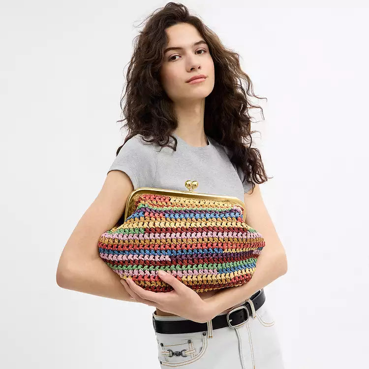 Multicolor straw shoulder bag by The Tiny Bag with large kisslock closure and spacious interior, stylish and vibrant accessory.