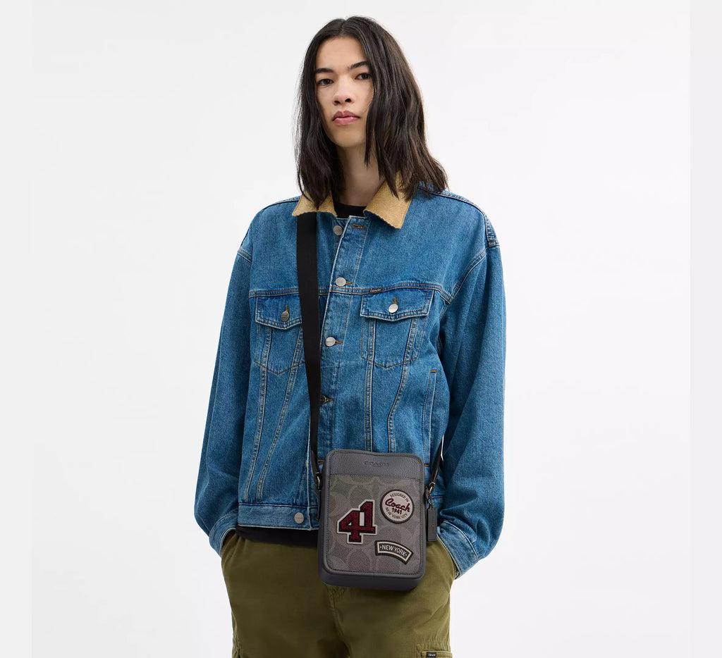 Coach men's Sullivan flap crossbody bag in signature leather and canvas, featuring a sleek, compact design with a shoulder strap.