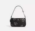Black leather Coach Nolita 19 shoulder bag with sparkly butterfly print and compact design, by The Tiny Bag.