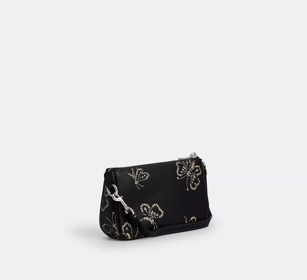 Black leather Coach Nolita 19 shoulder bag with sparkly butterfly print and silver hardware, stylish and compact for everyday use.