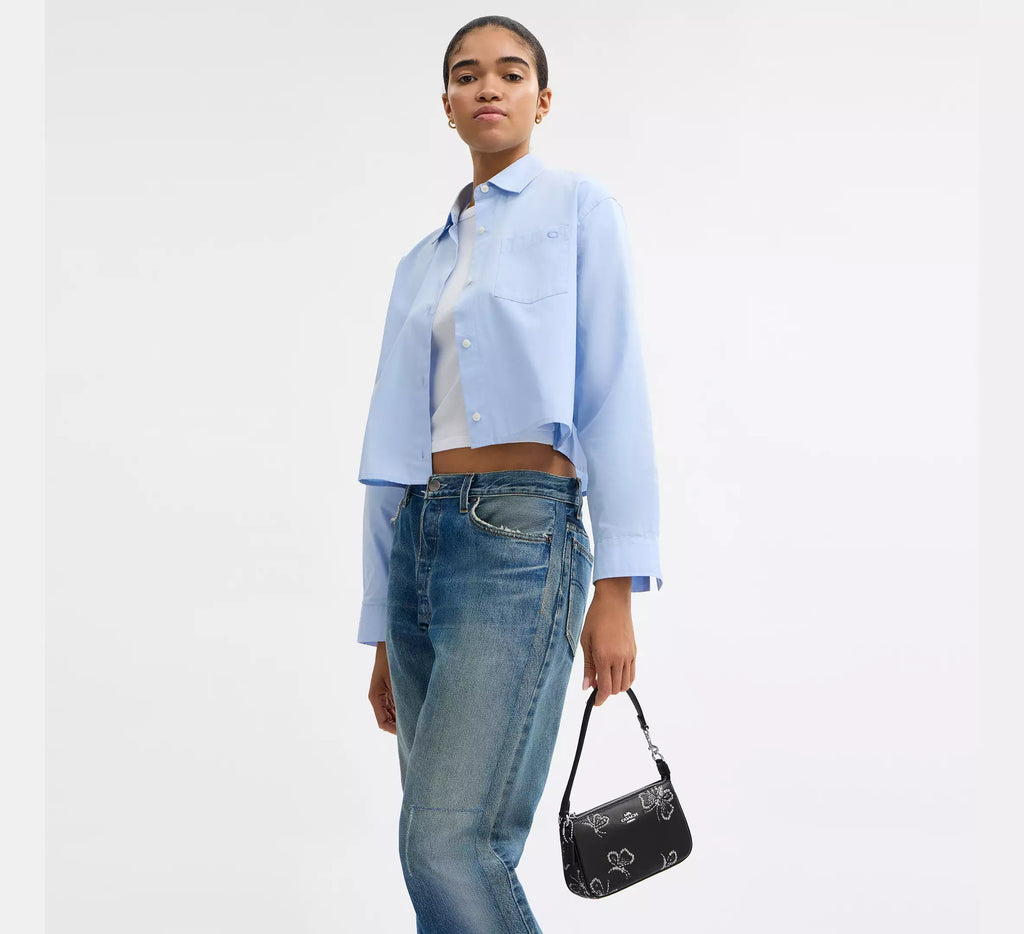 Black leather Coach Nolita 19 shoulder bag with sparkly butterfly print, featuring a compact design and stylish details.