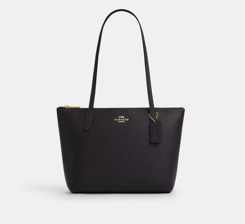 Black leather COACH Fiona Zip Tote Bag with gold accents, featuring a spacious design and sleek leather finish.