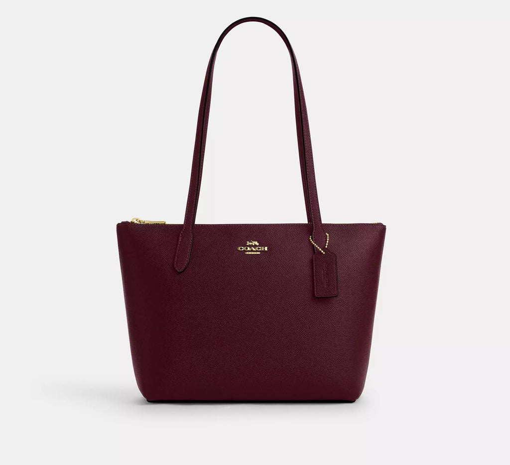 Coach CW395 Fiona zip tote bag in crossgrain leather with gold and dark wine accents, featuring a spacious design and sturdy handles.
