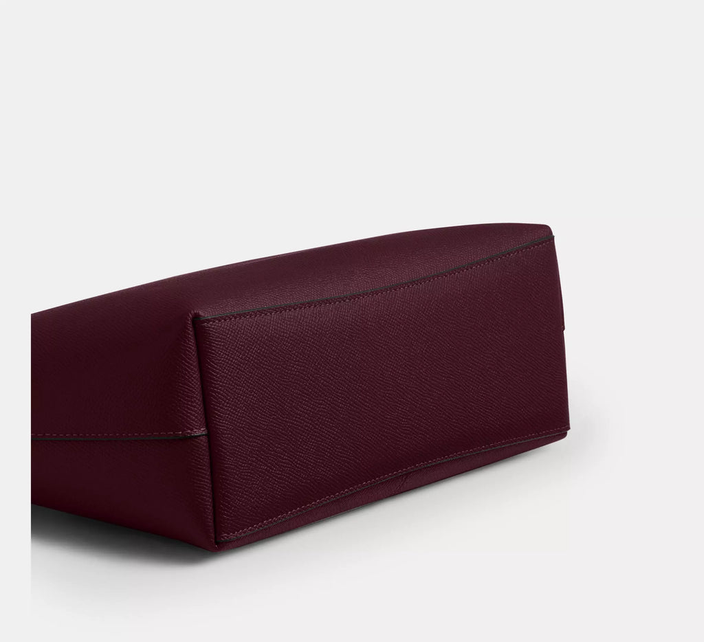 The Tiny Bag COACH CW395 Fiona zip tote bag in crossgrain leather with gold and dark wine accents, featuring a spacious design.