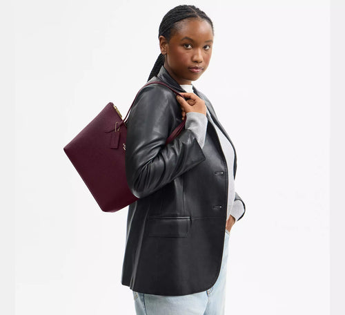 Coach CW395 Fiona zip tote bag in crossgrain leather with gold and dark wine accents, featuring a spacious design and top zipper closure.