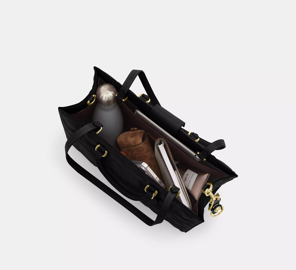 Black Coach Maggie large tote bag in signature leather, shoulder bag style, with spacious interior and sleek design.