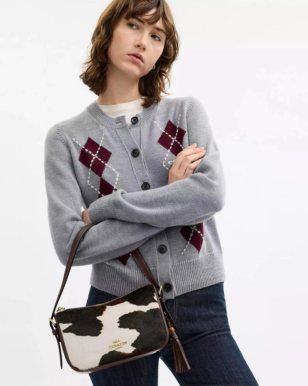 Coach Kailey crossbody shoulder bag with cow print tassel in brown and white, featuring the CC logo and compact design.