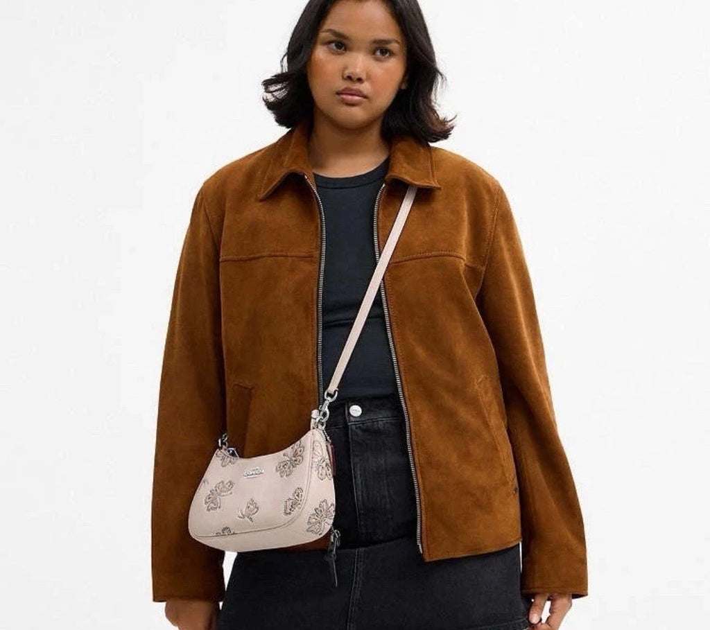 The Tiny Bag Coach Teri Shoulder Bag with butterfly print, black leather trim, and a sleek, stylish design.
