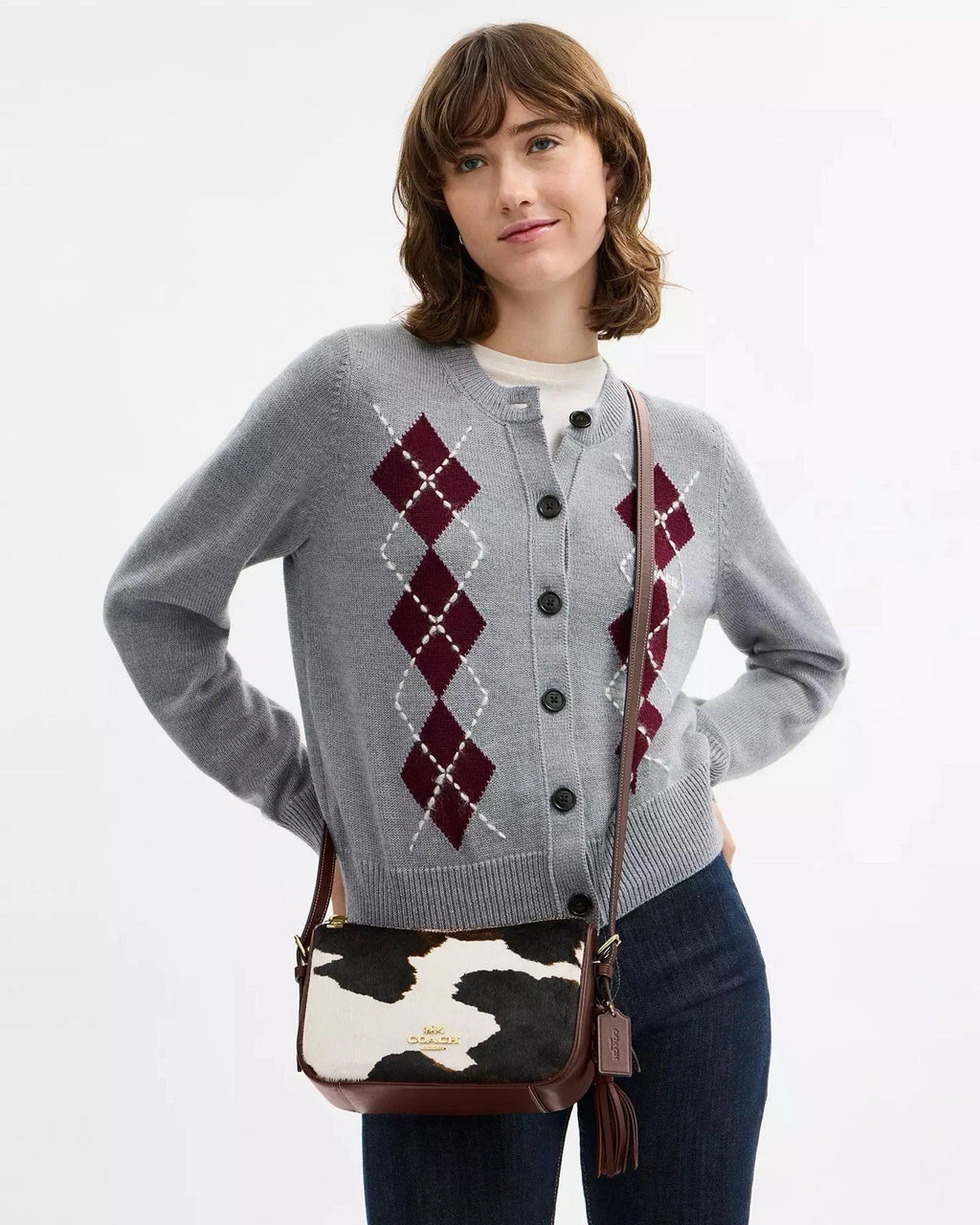 Coach Kailey crossbody shoulder bag with cow print design, tassel detail, brown and white colors, featuring the CCC logo.