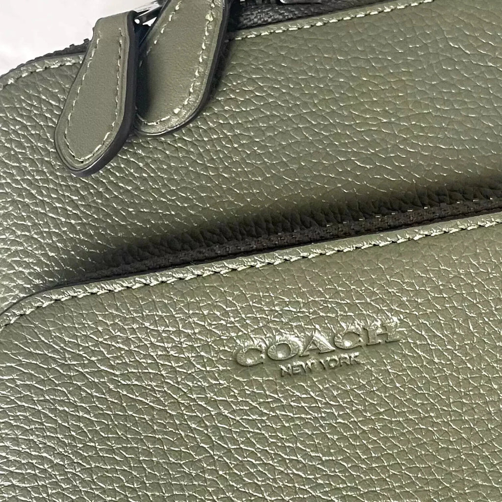 Small Coach Gotham Sling Pack in army green leather, stylish crossbody shoulder bag with compact design and sleek appearance.