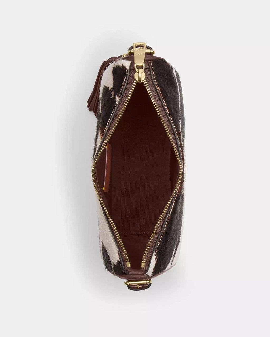 Coach Kailey crossbody bag with cow print design, tassel accents, brown and white leather, and signature CCC logo.
